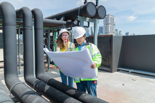 istock Engineer under checking the industry chilled water fan coil unit air conditioner is water cooling tower air chiller HVAC system of large industrial building to control air system 1403411187