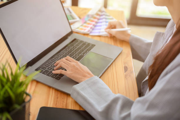 istock Young asian female graphic designer working in her office workplace, using laptop computer 1403411451