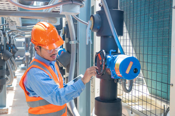 istock Engineer under checking the industry chilled water fan coil unit air conditioner is water cooling tower air chiller HVAC system of large industrial building to control air system 1403412313