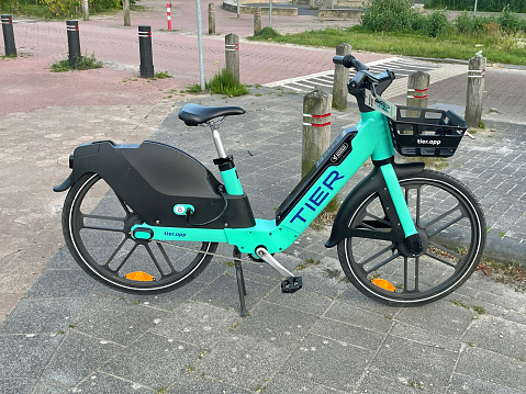 Almere, the Netherlands - June 16, 2022: Mint green Tier electric bicycle standing in the middle of the road.