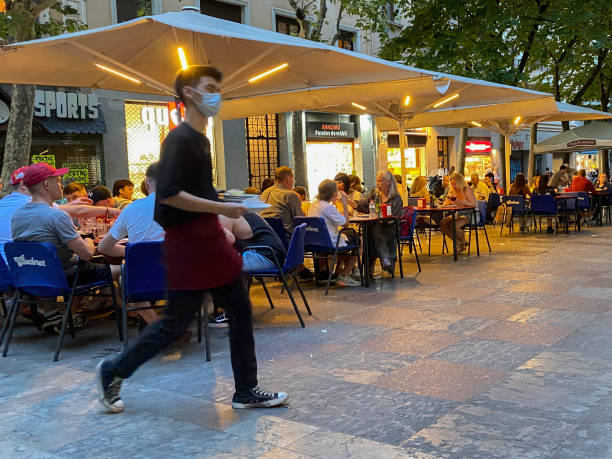 Barcelona, Spain, - May 22, 2022. Plaza at dusk with eating people on a boulevard in the city center of Barcelona.