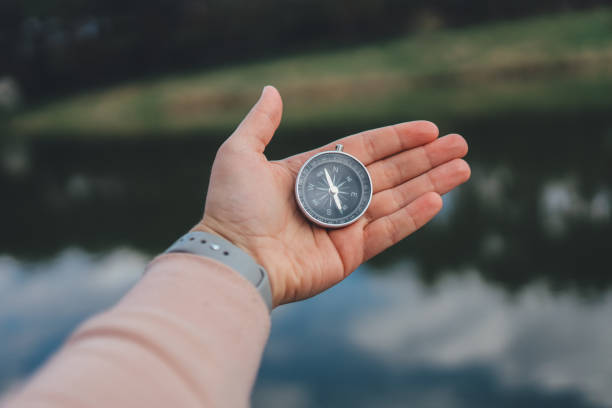 istock Compass in the hand on the nature background. 1403419139