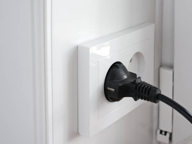 istock plug from an electrical appliance plugged into an electrical outlet on a light wall background 1403419409