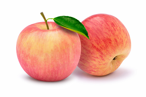 Closeup two whole pink fuji apples with green leaf isolated on white background. Full depth of field.