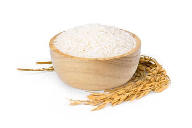 White rice in wooden bowl and rice ears on white White rice in wooden bowl and rice ears on white background, jasmine rice stock pictures, royalty-free photos & images