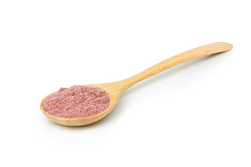 Pink powder in wooden spoon on white background.