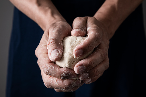 Kneading dough with ingredients in domestic kitchen