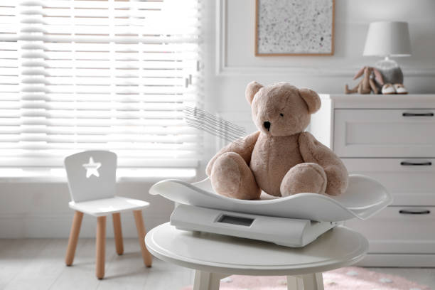 istock Baby scales with teddy bear on table in room 1403424874