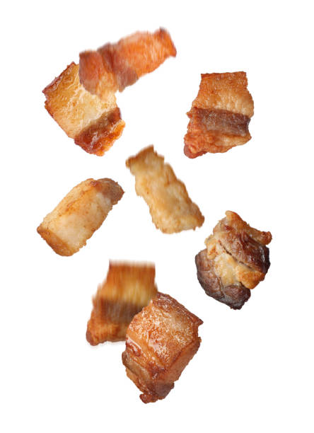 istock Tasty fried cracklings falling on white background. Cooked pork lard 1403424876