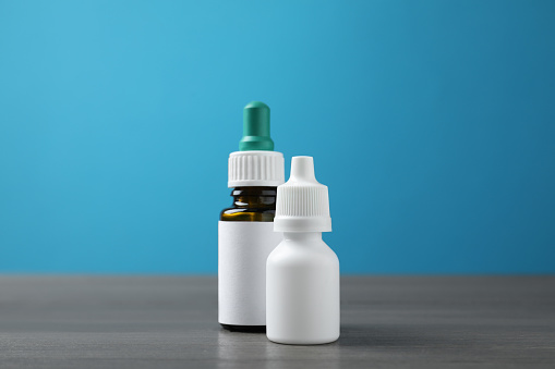 Bottles of nasal sprays on grey wooden table