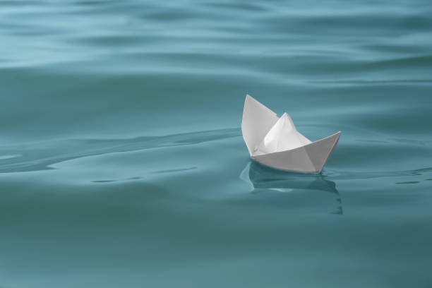 istock White paper boat floating on water surface, space for text 1403425040