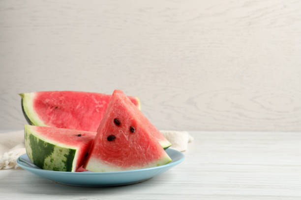 istock Delicious fresh watermelon slices on white wooden table. Space for text 1403426359