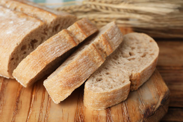 istock Cut fresh ciabatta on wooden table, closeup 1403426427