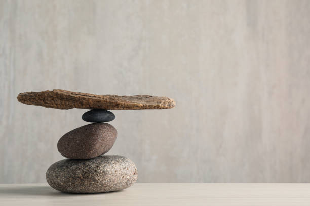 Stack of stones with tree branch on wooden table, space for text. Harmony and balance concept Stack of stones with tree branch on wooden table, space for text. Harmony and balance concept pebble shapes stock pictures, royalty-free photos & images