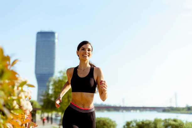 istock Young woman taking running exercise by the river promenade 1403429737