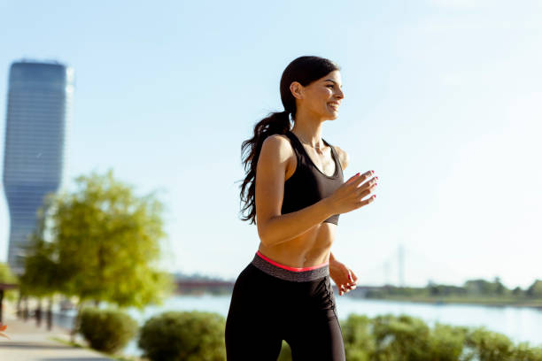 istock Young woman taking running exercise by the river promenade 1403429741