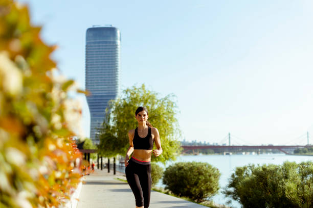 istock Young woman taking running exercise by the river promenade 1403429777