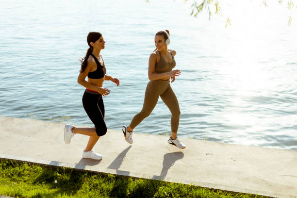 istock Young woman taking running exercise by the river promenade 1403430070