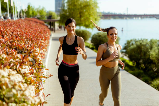 istock Young woman taking running exercise by the river promenade 1403430090