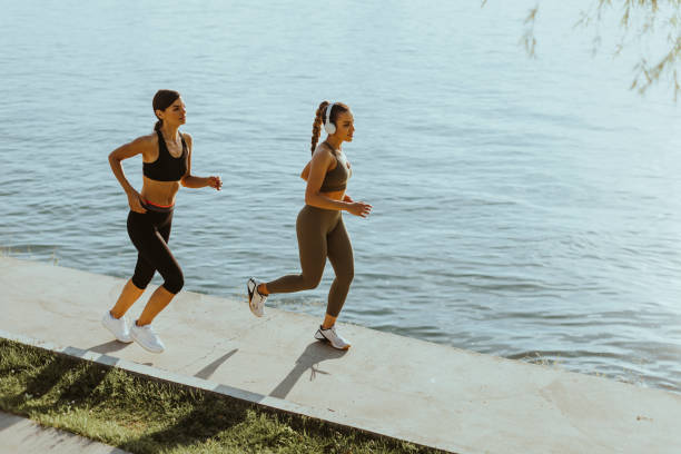 istock Young woman taking running exercise by the river promenade 1403430094