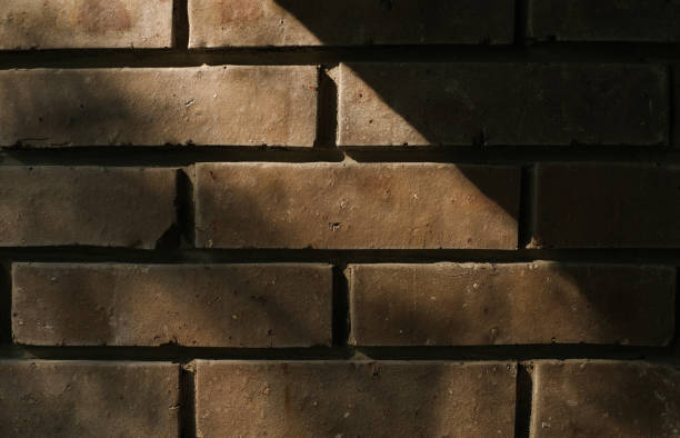 istock Brick wall background with contrast sunlight and shades 1403433322