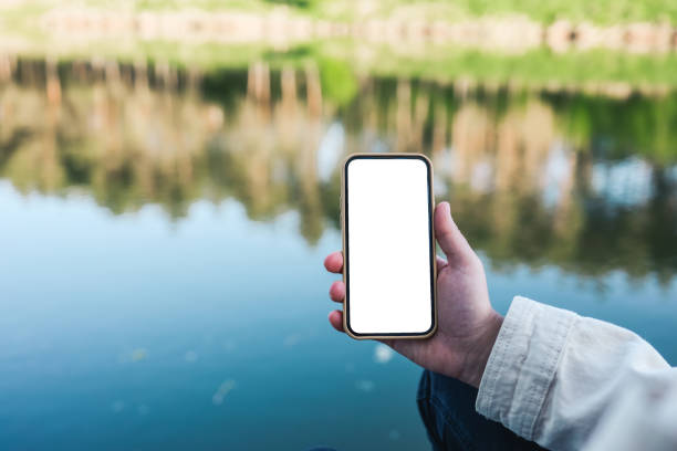istock Phone with isolated screen on the background of the river 1403433498