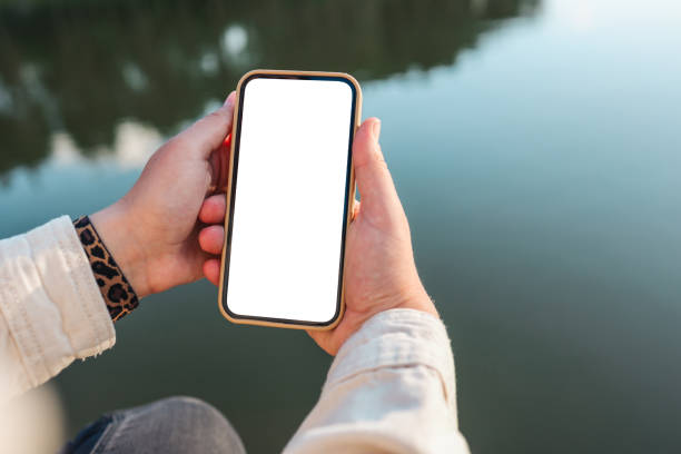 Phone with isolated screen on the background of the river stock photo