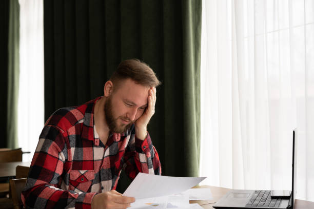 istock sad businessman with documents and paperwork in the office. analyzing forecasting financial rates. business, people, deadline, stress and paper 1403434768
