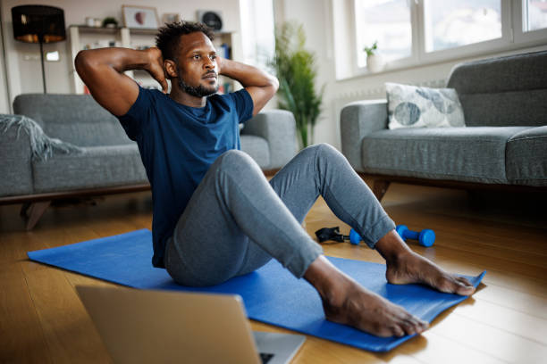 istock Young athletic man doing sit-ups in the living room 1403436635