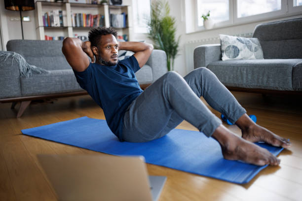 Man exercising at home Man exercising at home sit ups stock pictures, royalty-free photos & images