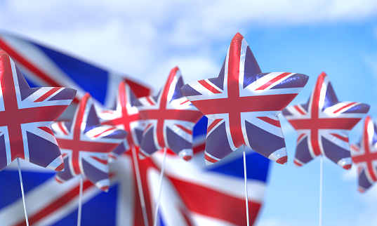 Balloons in the colors of the flag of UK fly in the blue sky. Celebration Concept.