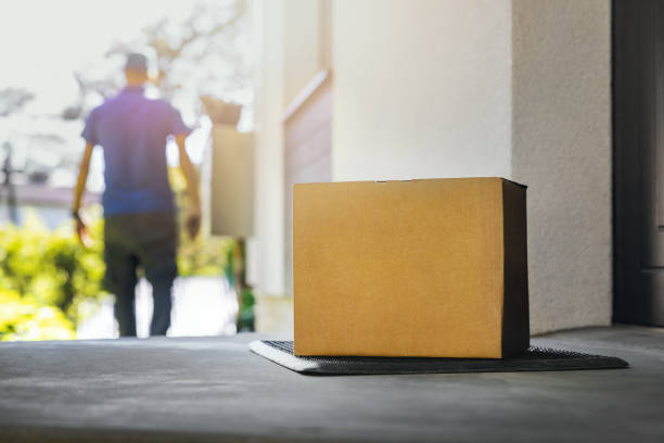 caja de envío en blanco en el porche de la casa. servicio de entrega a domicilio - servicio de entrega fotografías e imágenes de stock