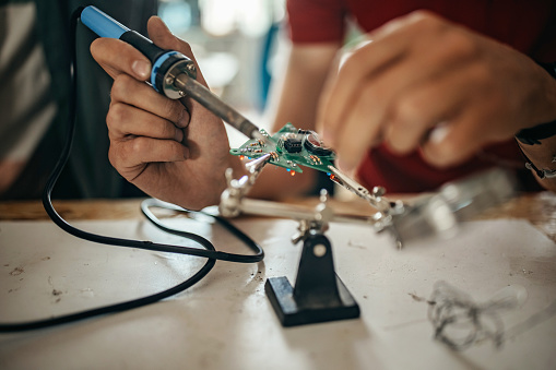 Close up photo of human hands soldering electrical components