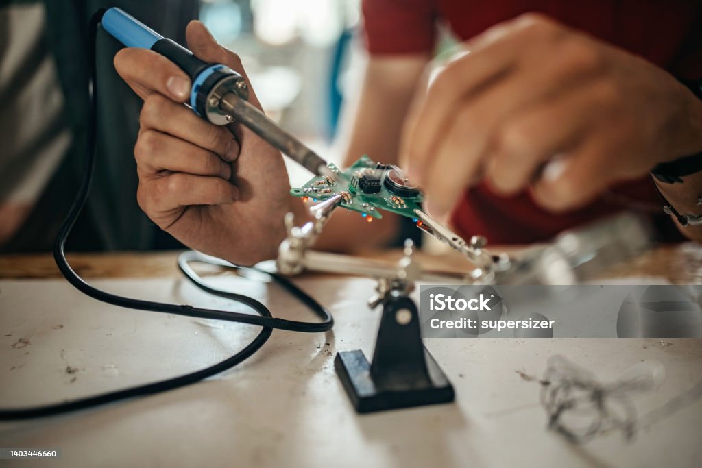 I will teach you Close up photo of human hands soldering electrical components Vocational Education Stock Photo