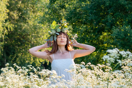 Beautiful brunette woman in flower wreath. Summer solstice day. Midsummer festival.