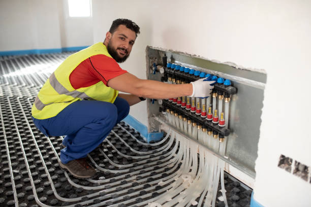 istock Man installs and checks underfloor heating. Floor heating system installation 1403448949