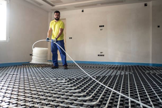 Man installs and checks underfloor heating, pipe roll install
