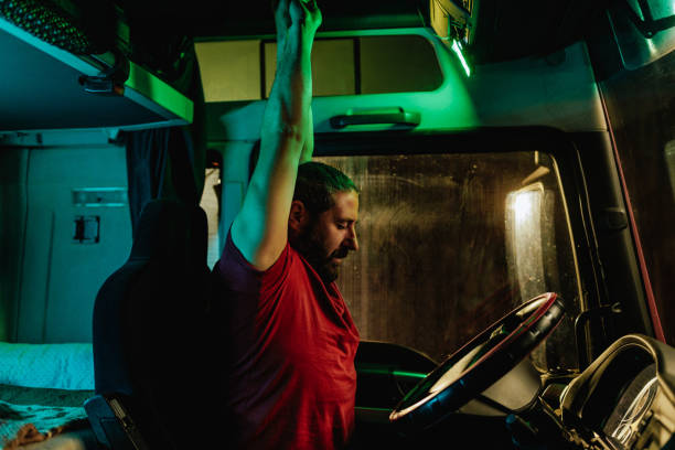 istock Tired truck driver stretching in cabin after nightshift 1403450169