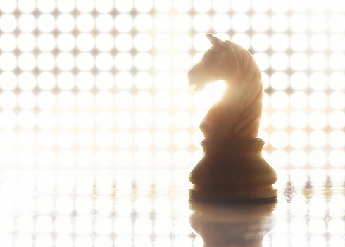 Chess knight surrounded by dazzling light and pattern.