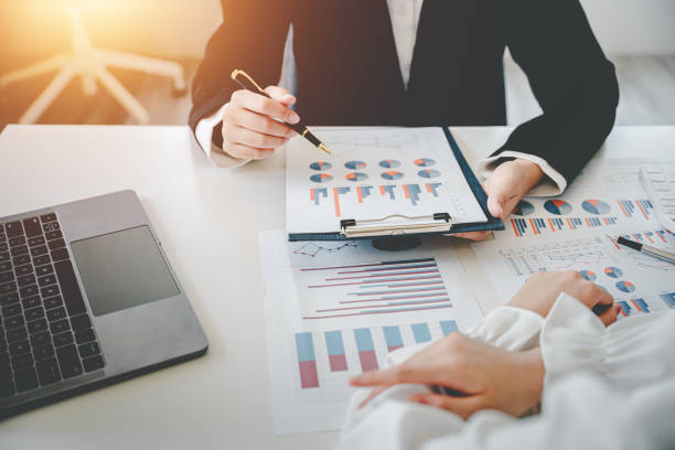 istock Teamwork with price chart analyzes business people on the table at the conference room. 1403454534