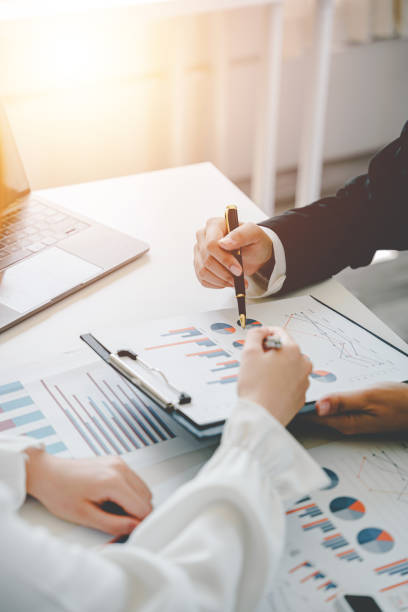 istock Teamwork with price chart analyzes business people on the table at the conference room. 1403454629