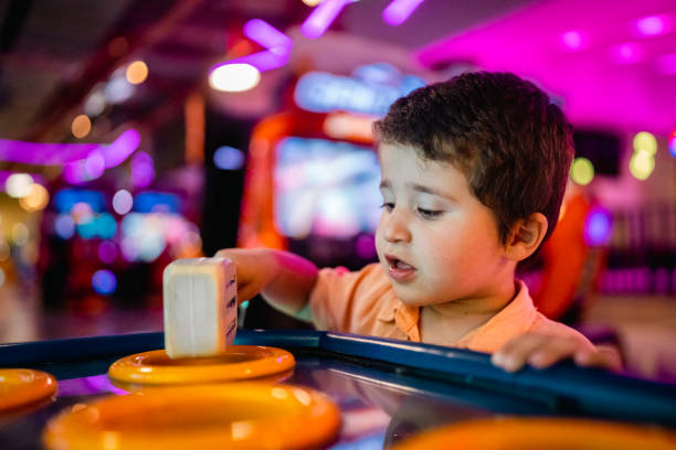 mały chłopiec bawiący się w salonie gier - amusement arcade machine toy leisure games zdjęcia i obrazy z banku zdjęć