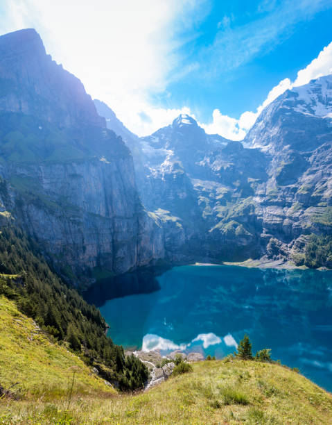 View over the lake Oeschinensee and the surrounding steep mountain cliffs stock photo