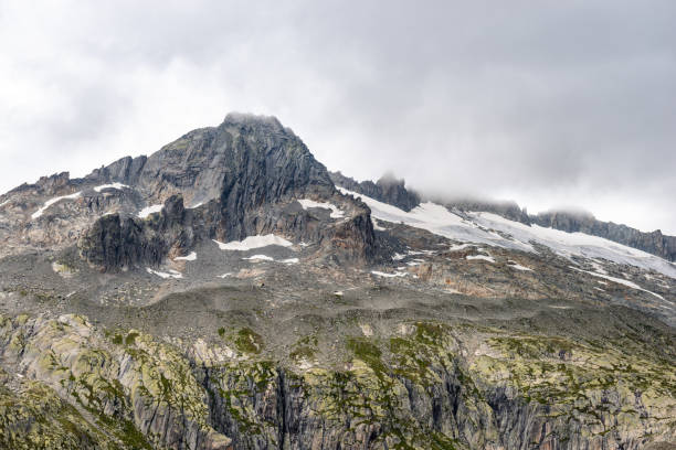 istock a mountain peak surrounded by thick clouds in the swiss alps 1403456093