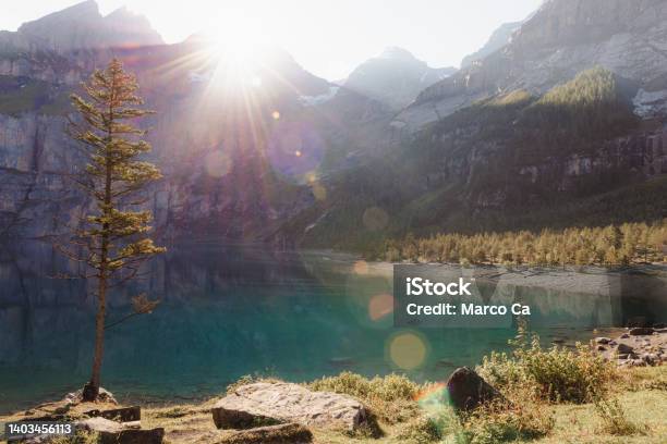 The First Rays Of Sun Over The Mountain Peaks At Lake Oeschinen Stock Photo - Download Image Now