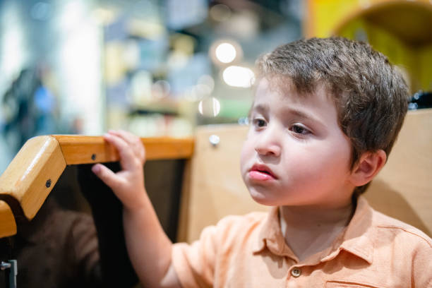 A one year old baby boy looking up at the camera.