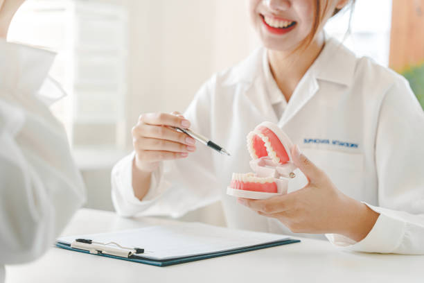 portrait d’une femme dentiste elle recommande des méthodes de soins dentaires dans le cabinet de son dentiste. - dentist surgery dental hygiene using voice photos et images de collection