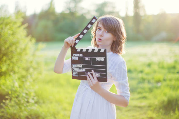 istock Woman holds clapper board at sunset 1403464249