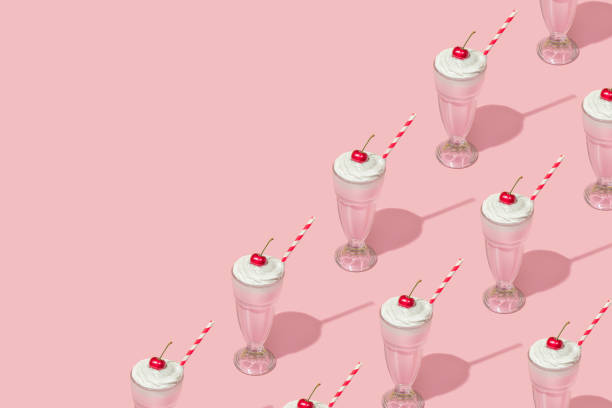 Retro romantic creative patten with strawberry milkshake with cherry on top on pastel pink background. 70s, 80s or 90s retro fashion aesthetic idea. Valentines day romantic idea.