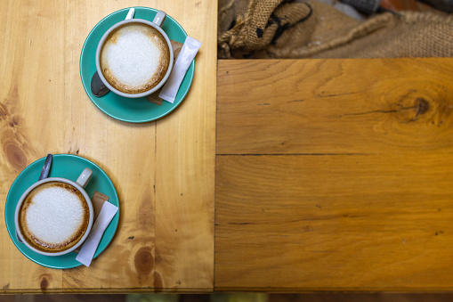 Cappucino in the cup on the table in the coffee shop